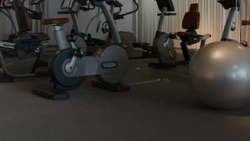 Una sala de gimnàstica amb bicicletes estacionàries i una pilota d'exercici.