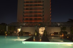 Enjoy a refreshing swim in the hotel's pool surrounded by lush greenery and a glass roof offering a view of the sky.