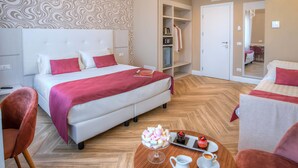 Habitación de hotel con una cama grande, una mesita de noche con una bandeja de comida, un armario y un espejo.