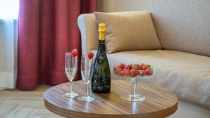 Una mesa de madera con una botella de champán, dos copas vacías y un cuenco de fresas.