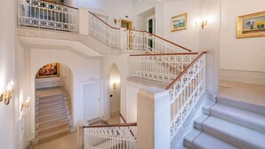 Eine mehrstufige Treppe mit aufwendig gestalteten weißen Geländern und einem Teppichboden.
