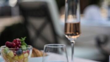 A dining table with a dessert bowl, a glass of water, and a glass of champagne.