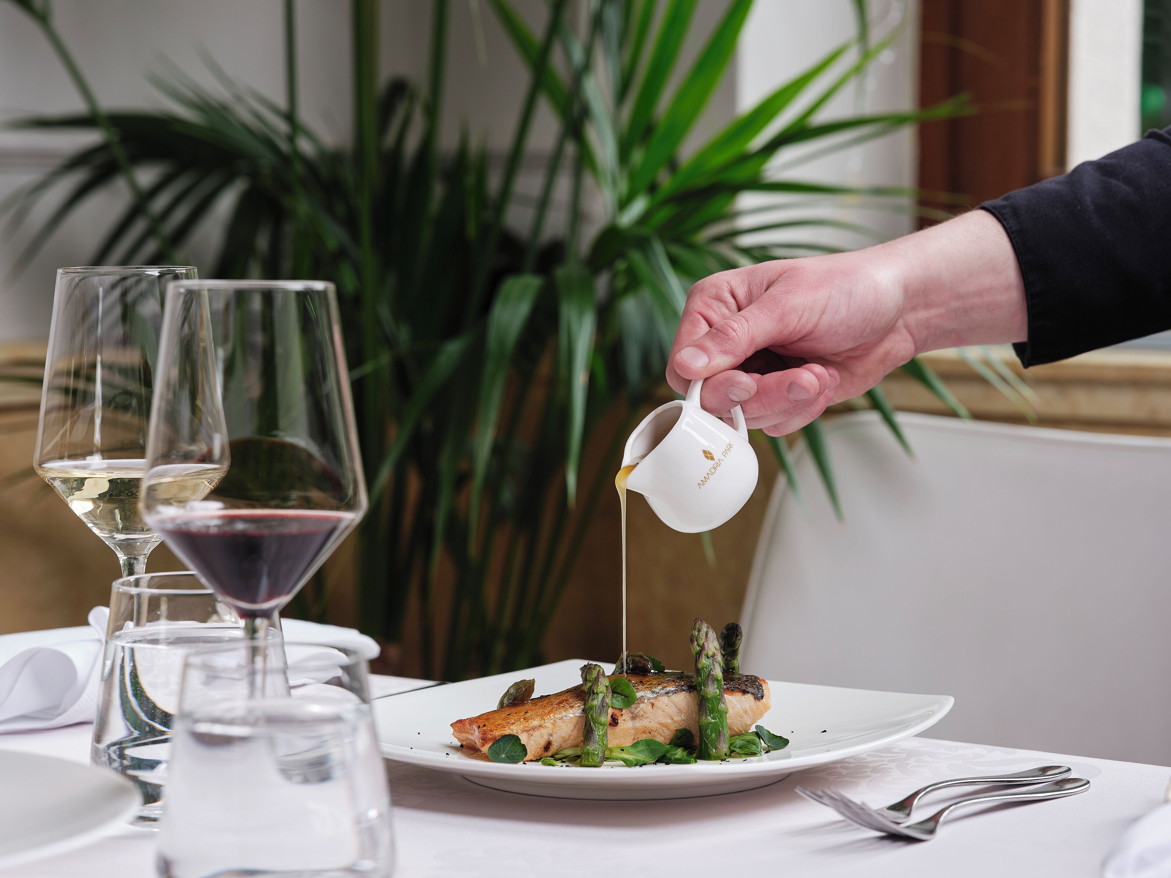 A dining table with a plate of food, glasses, and a pitcher.