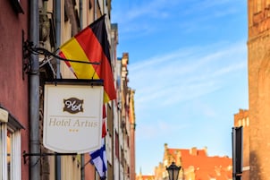 A hotel sign with the name "Hotel Artus" and multiple flags.