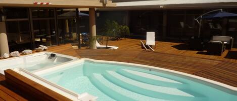 Piscina a l'aire lliure, para-sols i gandules