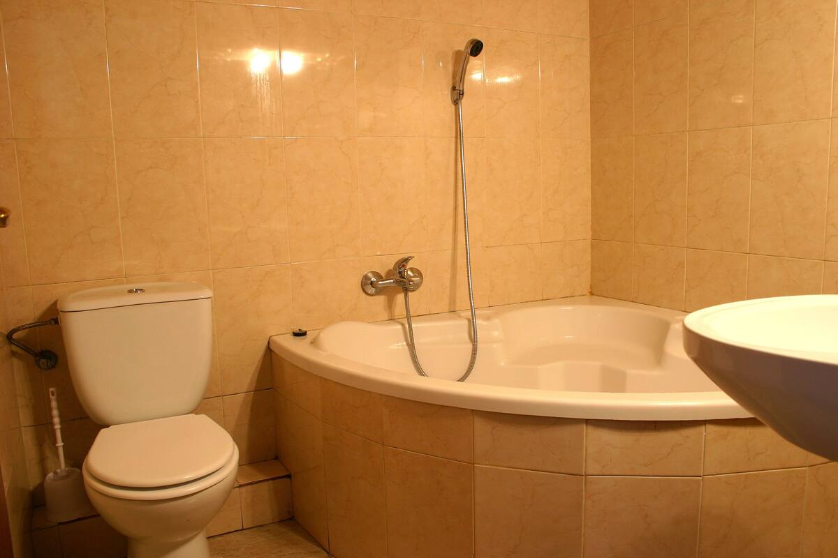 A bathroom with a toilet, a bathtub, and a sink.