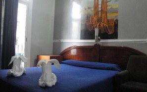 Una habitación de hotel con una cama, una silla y un cuadro en la pared.