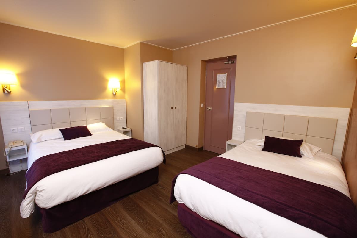 A hotel room with two beds, a wardrobe, a door with a notice, and bedside lamps.
