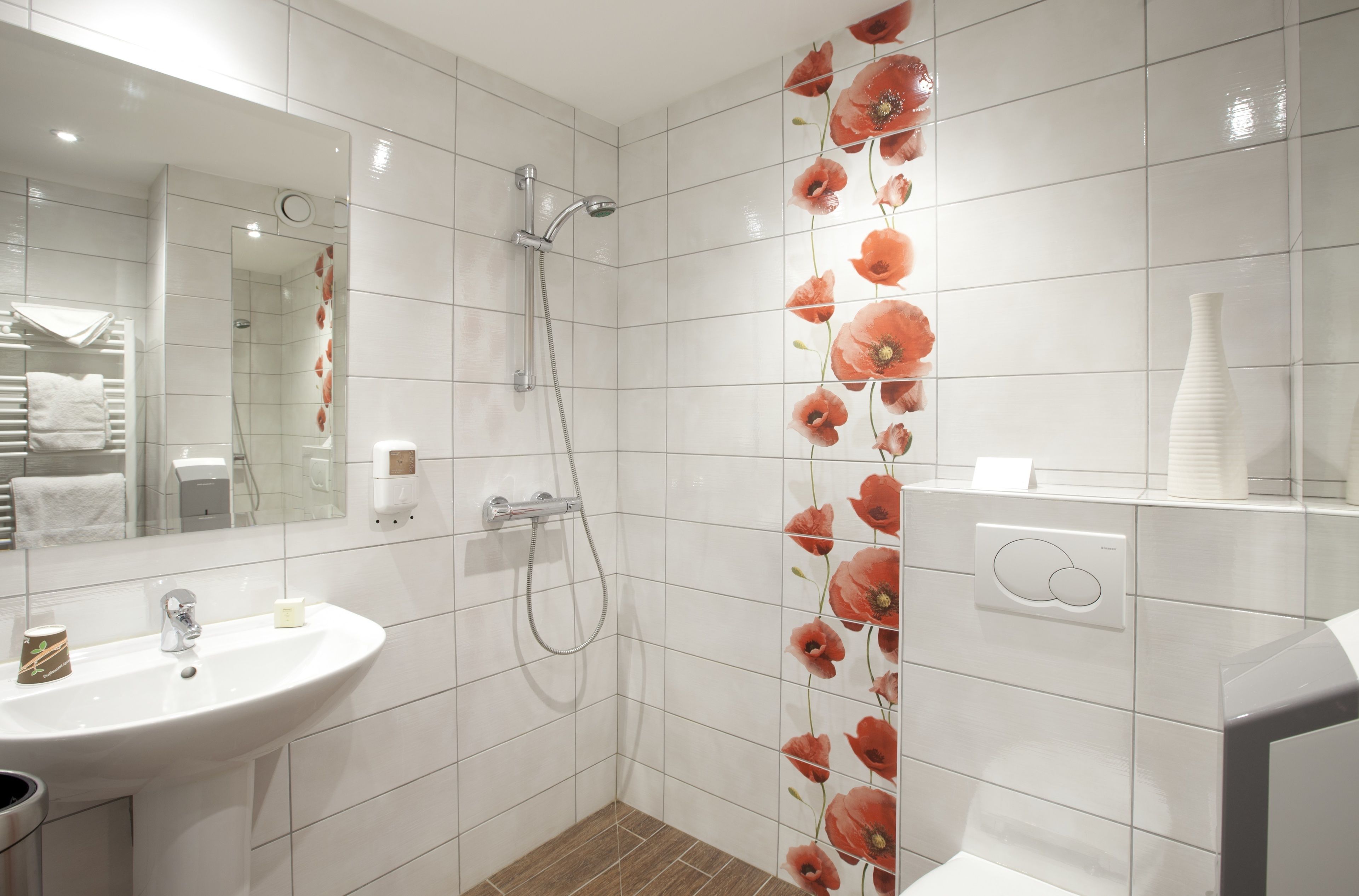 Un baño moderno con ducha, lavamanos y espejo.