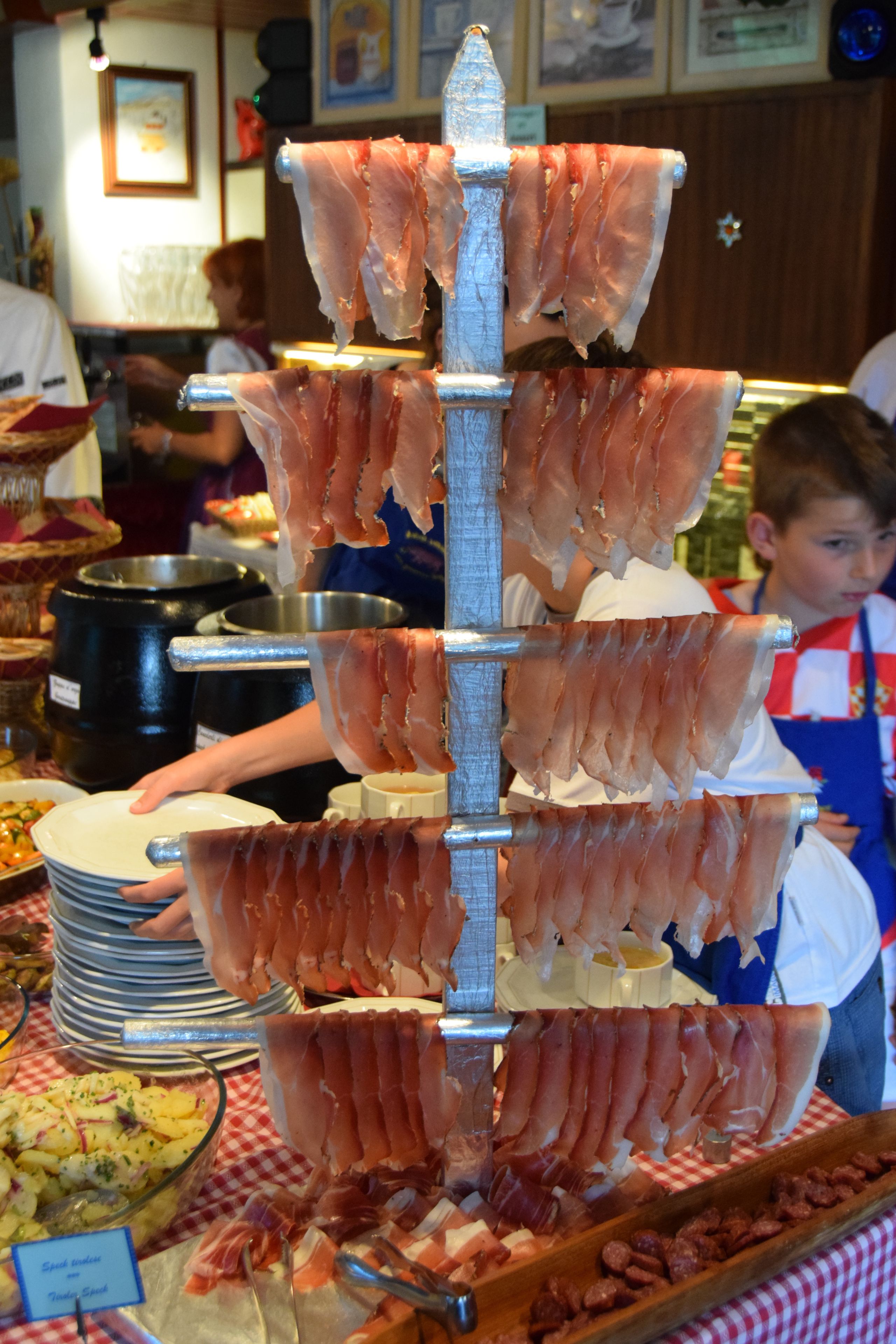 A buffet with various food items, including a meat carving station and a bowl of potato salad.