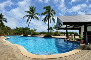 Una piscina al aire libre, camas de piscina gratis, sombrillas