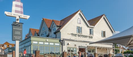 Un edificio frente al mar con un letrero que dice "The Botany Bay Bar Restaurant Coffee Lounge Function Rooms".