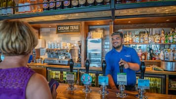 A bar with multiple beer taps, a cream tea section, and a variety of liquor bottles.