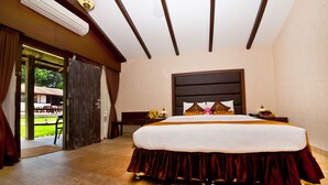 A hotel room with a large bed, a wooden ceiling, and a view of the outdoors. - 19Belo Cabana (Calangute)