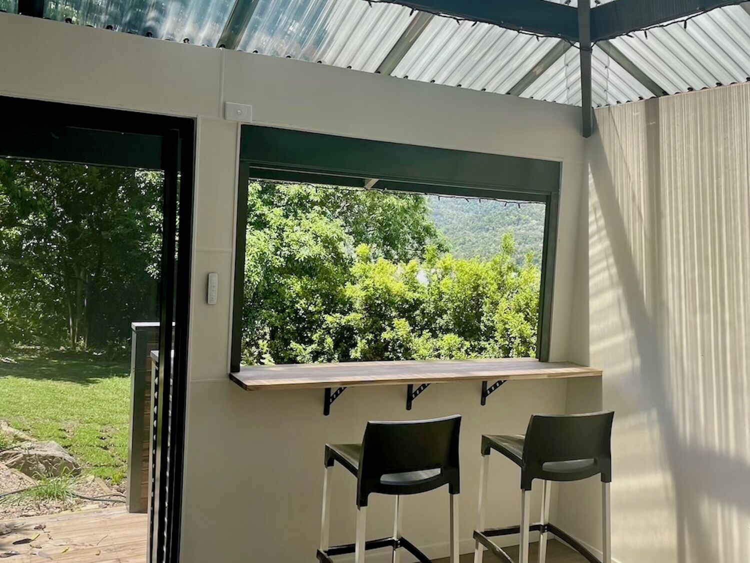 A room with a large window, two chairs, and a table.