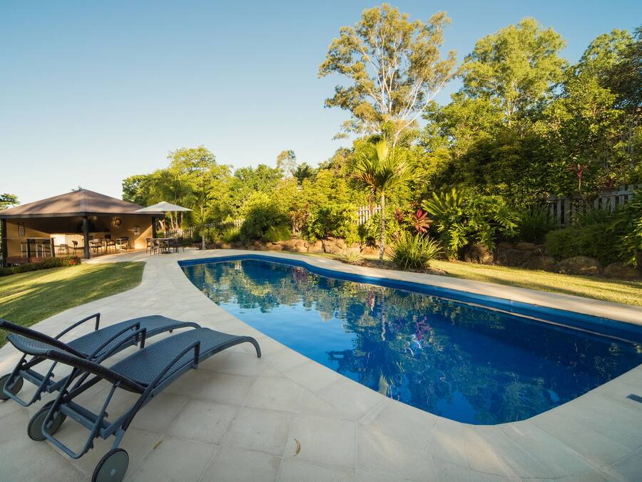 A swimming pool with lounge chairs and a covered pavilion.