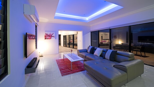 A modern living room with a sofa, a coffee table, and a flat-screen TV.