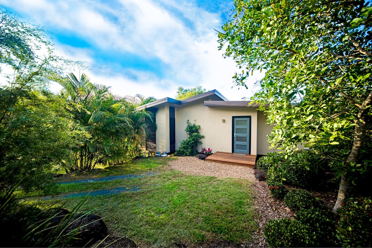 A modern house with a well-maintained garden, a paved driveway, and a front door.