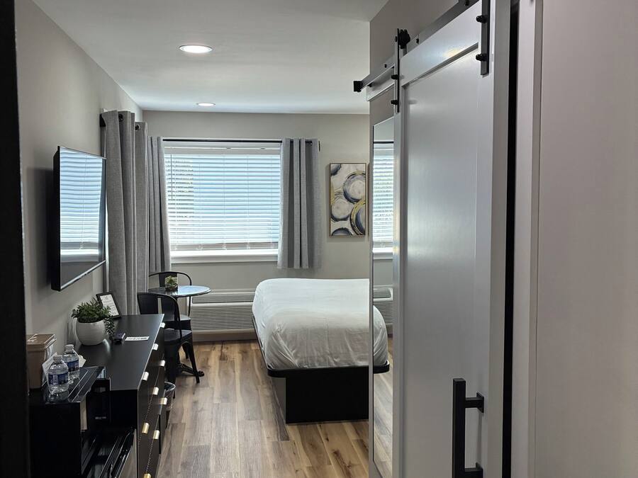 Une chambre moderne avec un lit, une table de chevet et un bureau avec des chaises.