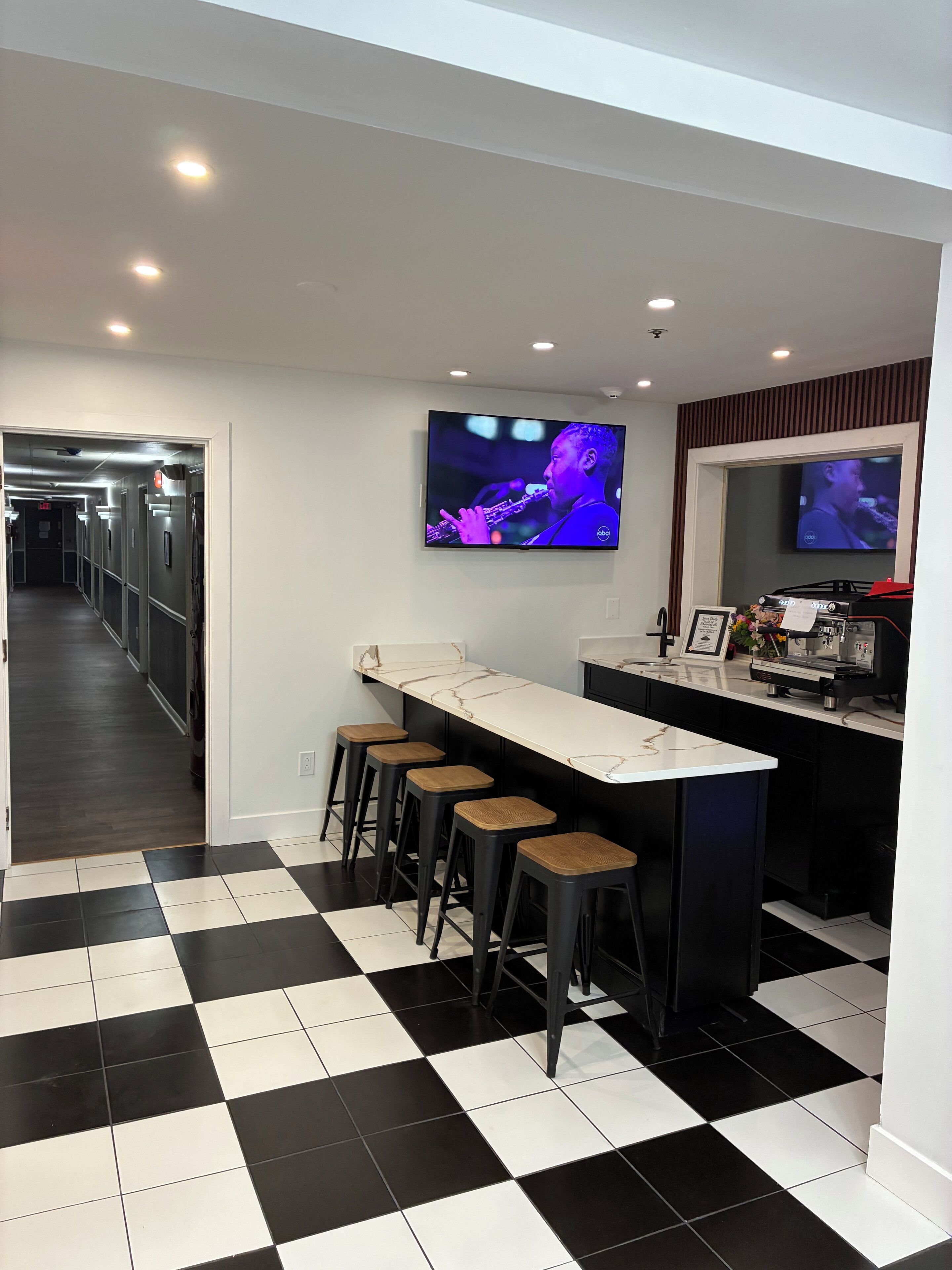 Une cuisine moderne avec un coin bar, un carrelage à motifs et un téléviseur à écran plat fixé au-dessus du bar.