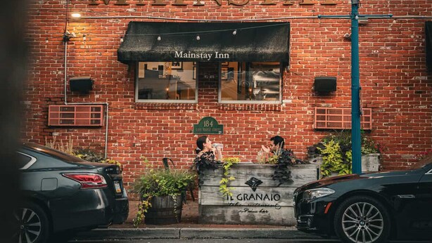 Un bâtiment en briques avec une enseigne indiquant « Mainstay Inn » et un lampadaire.