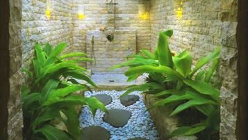Relax in a serene outdoor space with a stone pathway leading to a seating area featuring a bench and table.