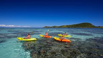 En la playa, arena blanca, sillas reclinables de playa, toallas de playa