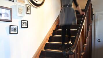 A staircase with wooden steps and a handrail, leading to a door at the top.