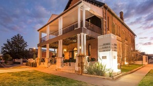 A two-story hotel with a covered porch and a brick facade.