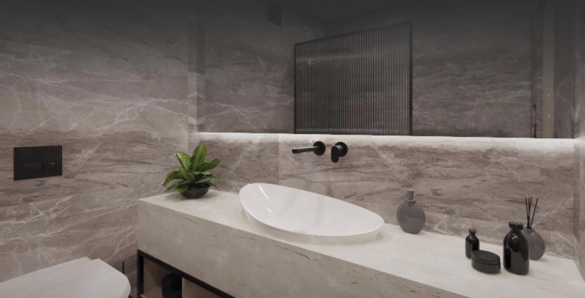 A modern bathroom with a marble wall, a white sink, a potted plant, and a mirror above the sink.