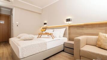 Ein modernes Hotelzimmer mit einem großen Bett, Nachttischen, einer Couch und einem Holz-Kopfteil.