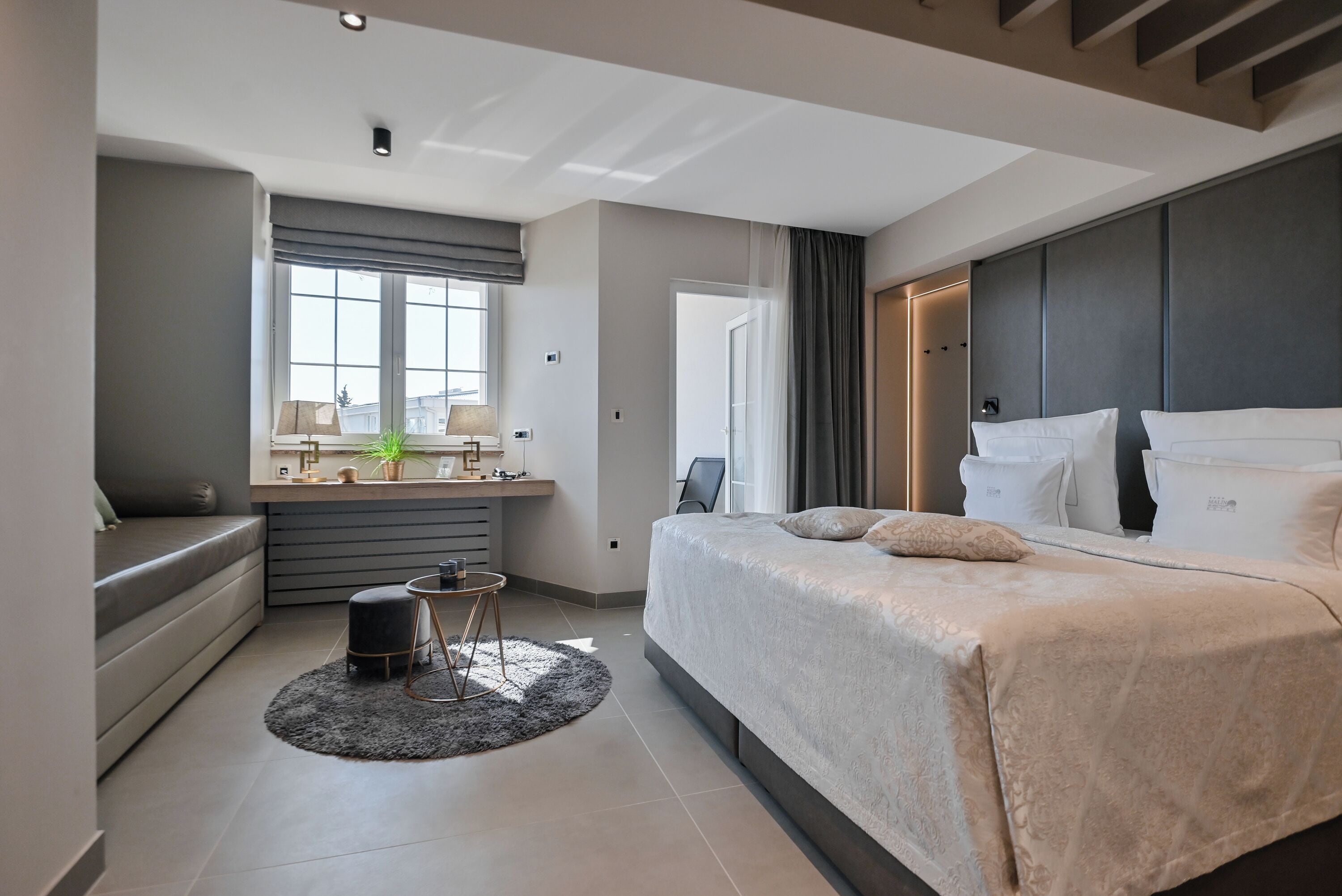 Un dormitorio moderno con una cama grande, un escritorio y una ventana.