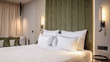 Habitación de hotel con una cama grande, cabecera con paneles verticales y dos lámparas de noche.