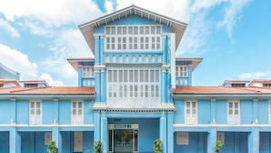 Un immeuble bleu avec une enseigne indiquant « HÔTEL 8 ».