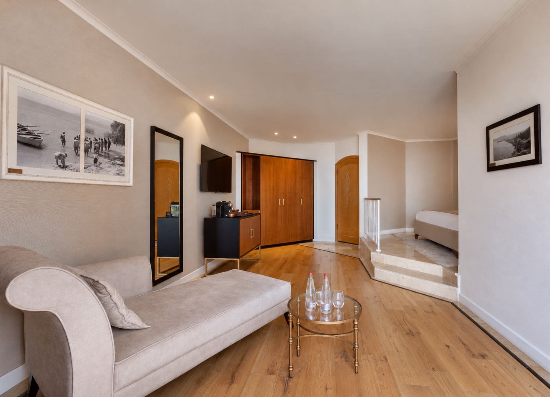 Ein modernes Wohnzimmer mit einer Couch, einem Couchtisch und einer Treppe, die in einen weiteren Bereich führt.