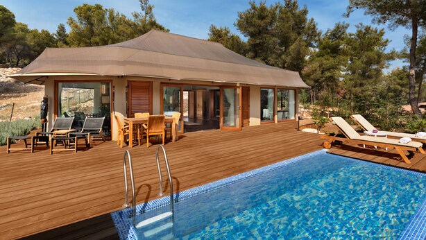 A wooden deck with a swimming pool, lounge chairs, and a covered patio area.