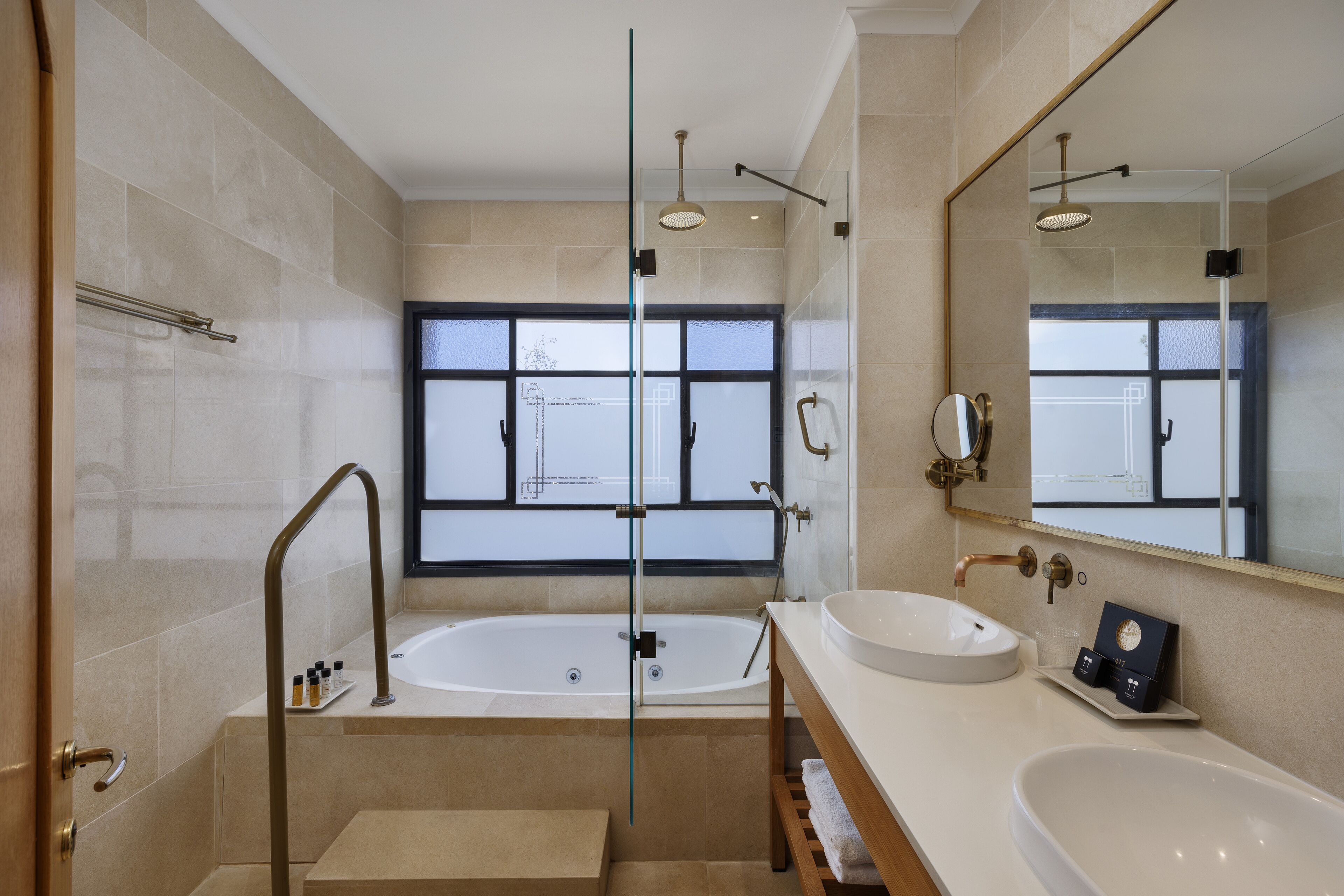 A modern bathroom with a glass-enclosed shower, a large bathtub, and a vanity with a sink and mirror.