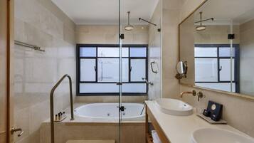 A modern bathroom with a glass-enclosed shower, a large bathtub, and a vanity with a sink and mirror.
