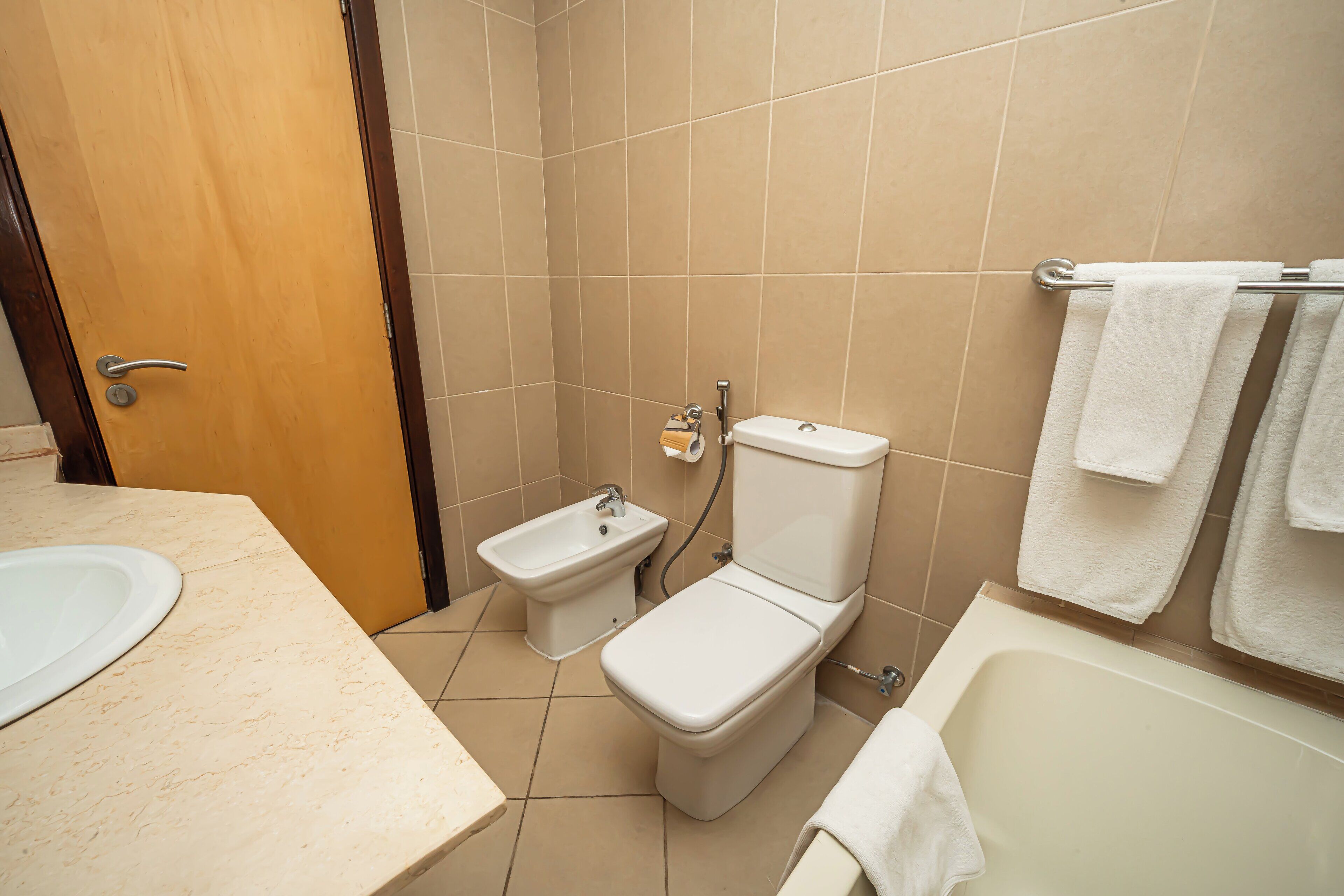 Un baño con lavamanos, bidé, inodoro y bañera.