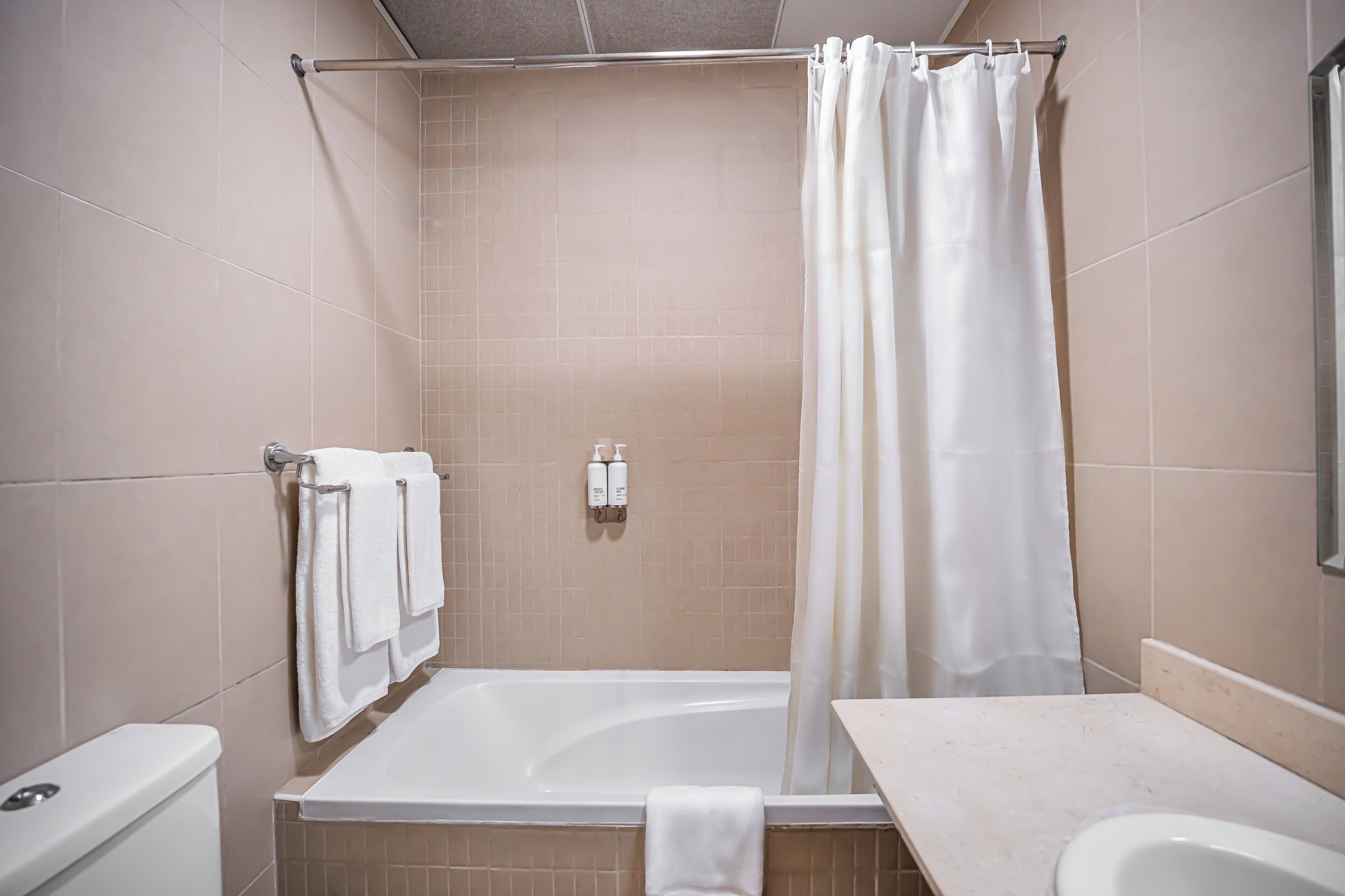 A bathroom with a bathtub, a toilet, and a sink.