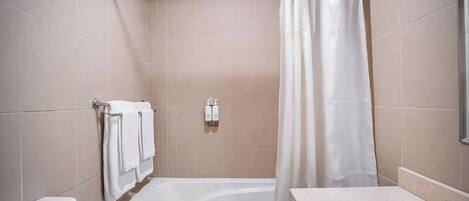A bathroom with a bathtub, a toilet, and a sink.