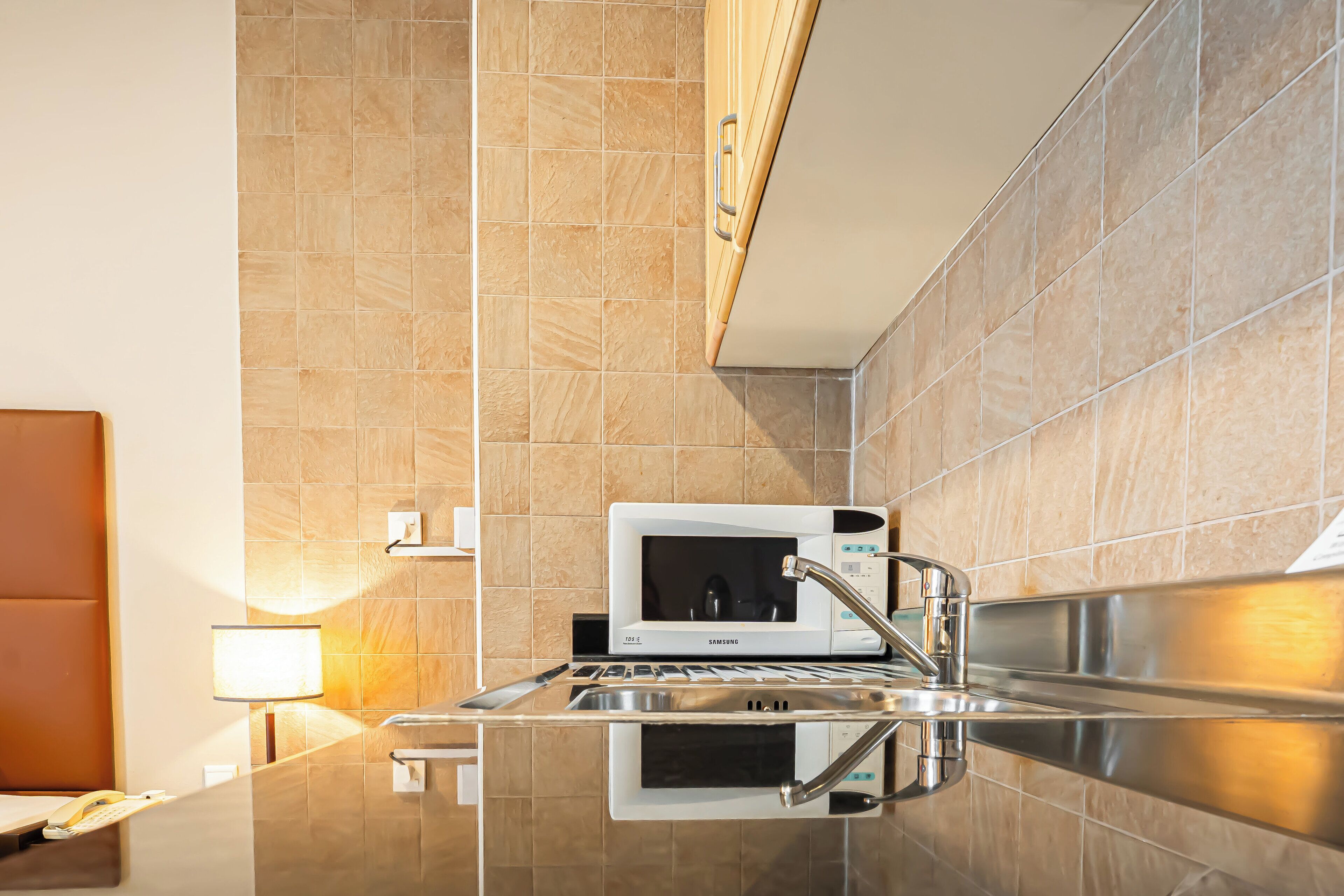 A modern kitchen with a built-in microwave, stainless steel sink, and a countertop.