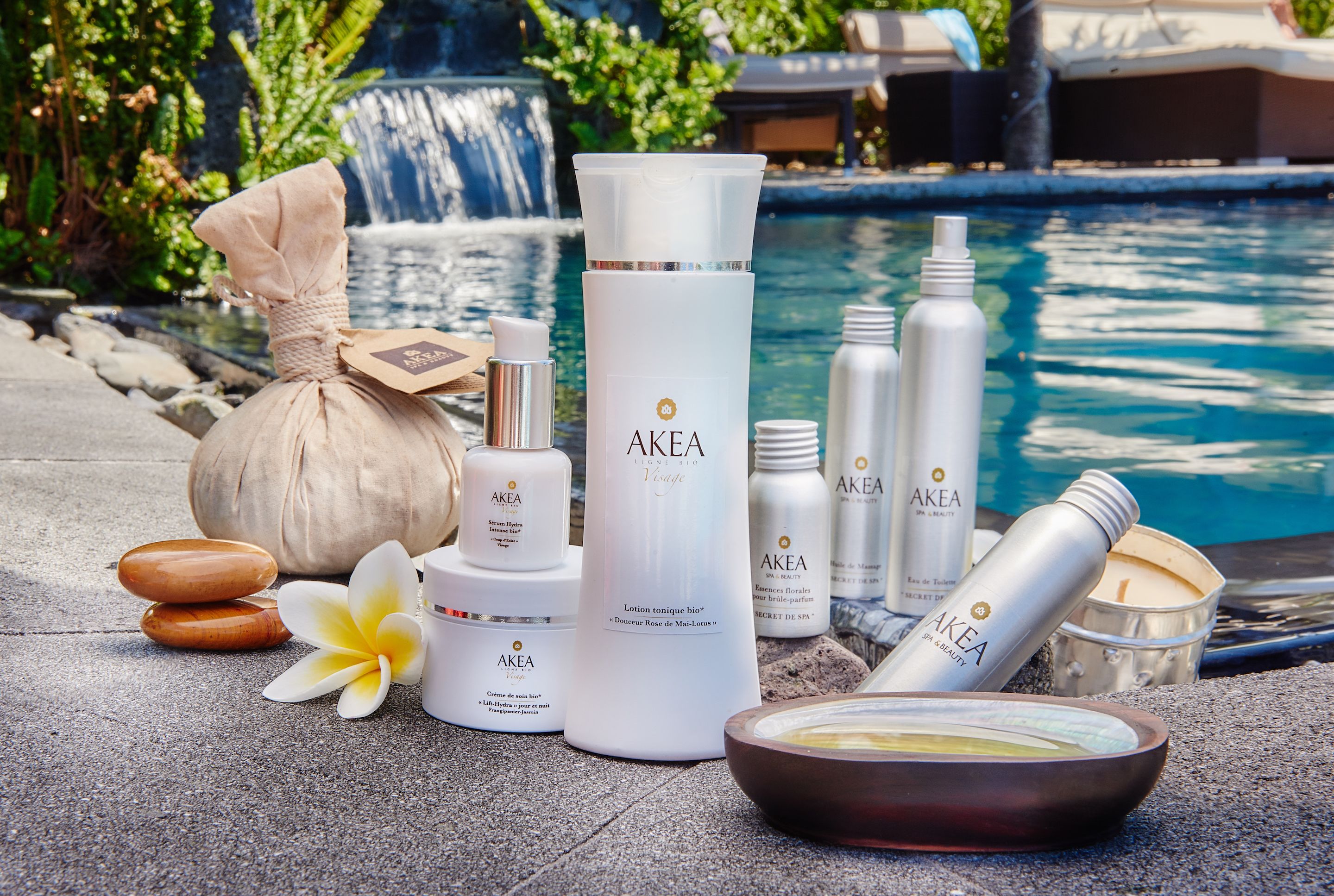 Un espacio de spa con diversos productos para el cuidado de la piel, un recipiente con sales de baño y una flor.