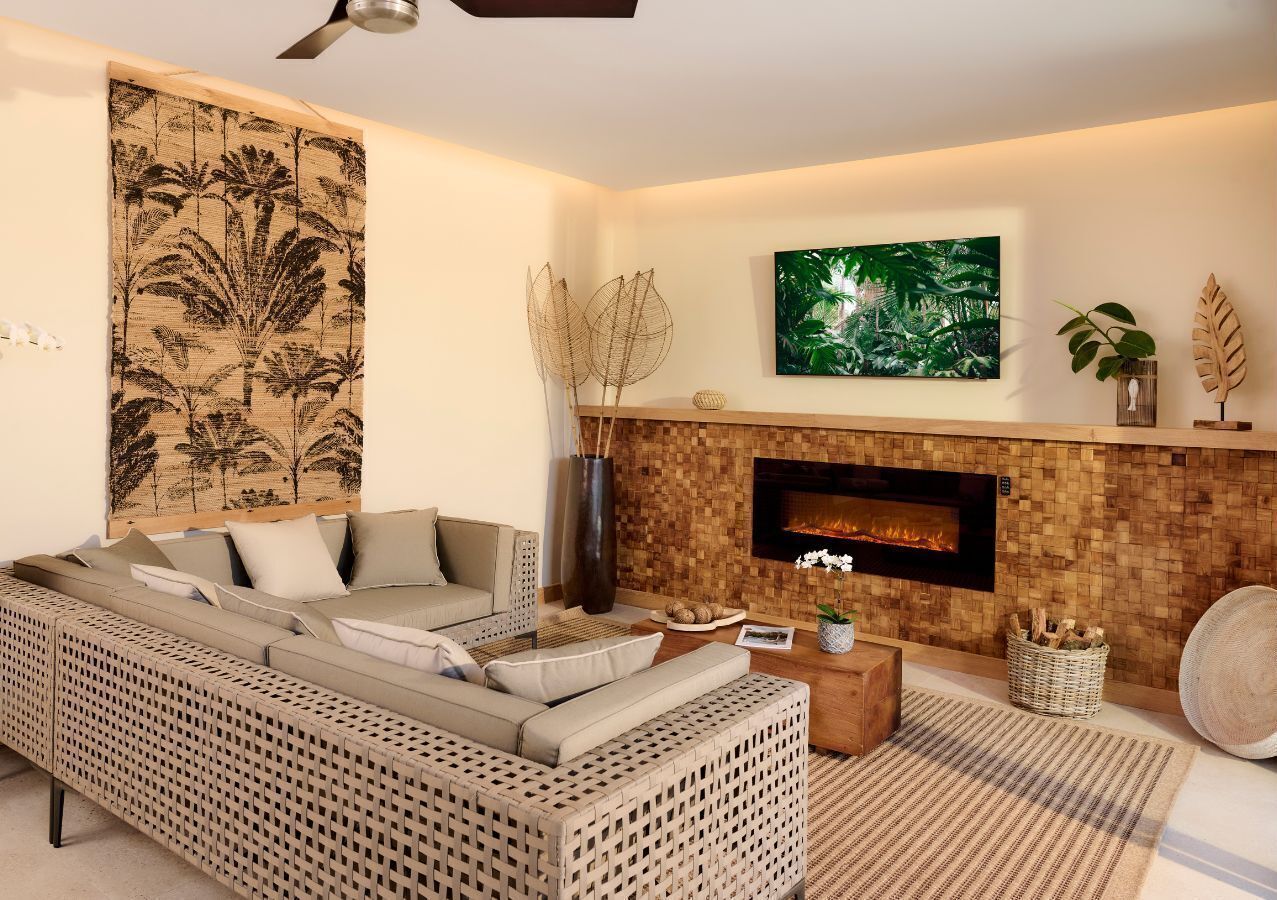 Un salon moderne avec un canapé, une cheminée et une grande tapisserie murale.