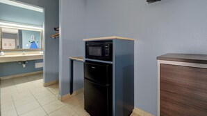 A compact kitchenette with a microwave, refrigerator, and a small countertop. - Weslaco Inn Weslaco/Mercedes (Weslaco)
