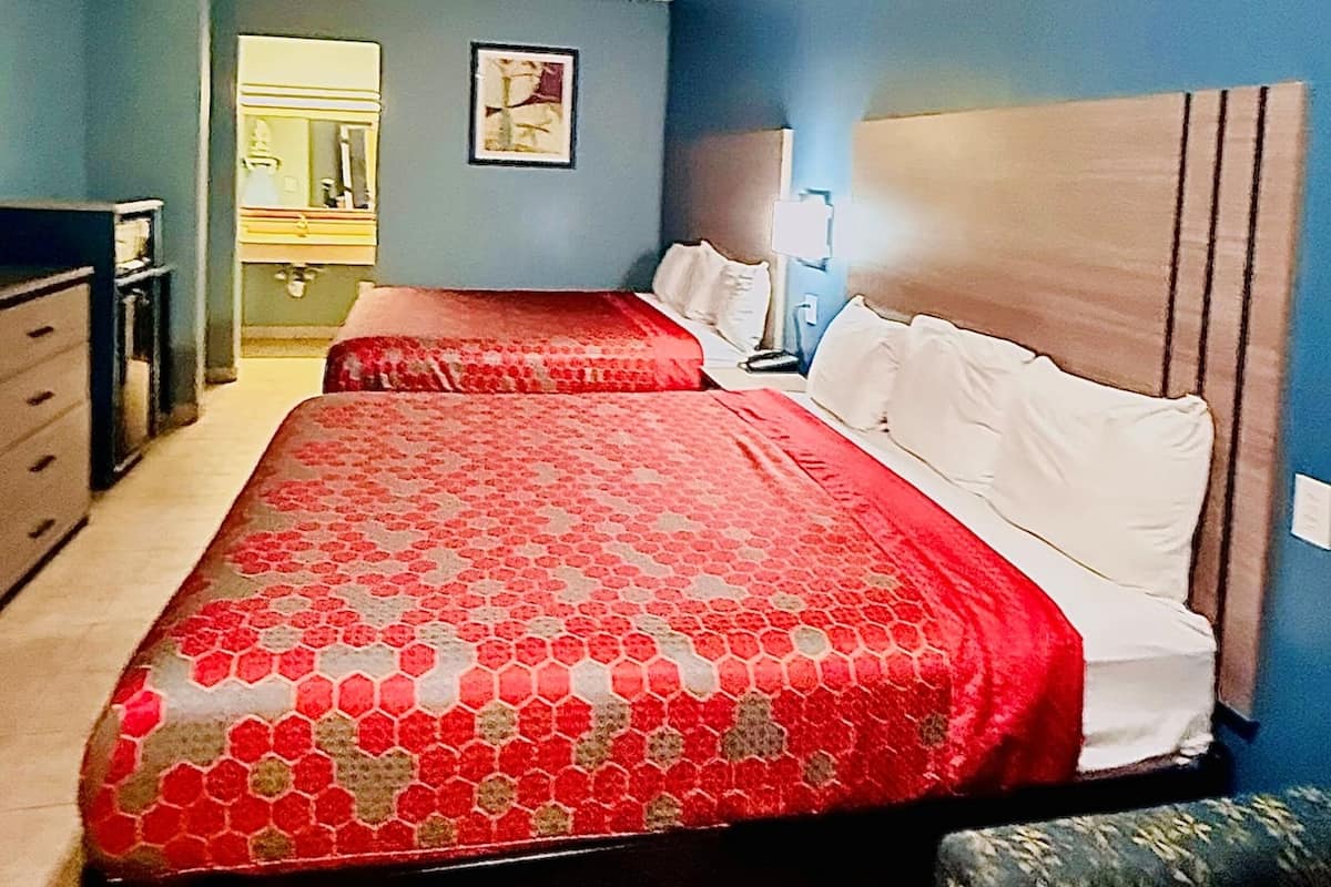 Une chambre à coucher avec un lit, une table de chevet, une commode et un miroir.
