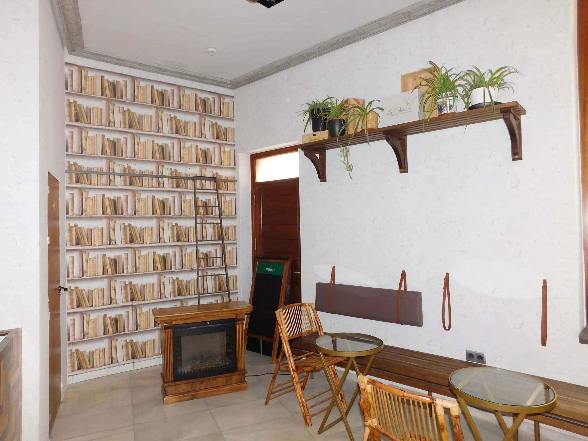 A room with a fireplace, bookshelves, a wooden bench, and a small table.