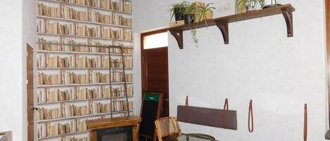 A room with a fireplace, bookshelves, a wooden bench, and a small table.