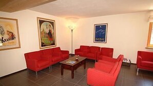 A room with red sofas, a coffee table, and framed pictures on the walls. - Nordend (Gressoney-la-Trinite)