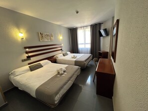 A hotel room with two beds, a desk, a TV, and a window with curtains. - Valdemoro (Valdemoro)